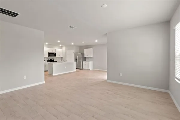 a view of kitchen with stainless steel appliances refrigerator stove microwave and cabinets