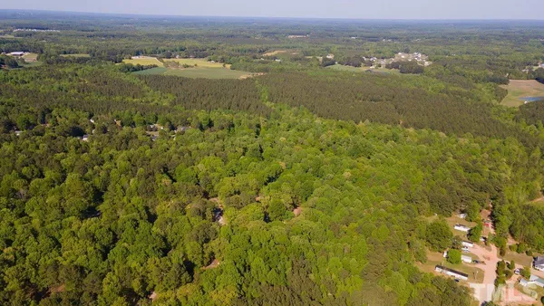 an aerial view of residential houses with outdoor space and trees