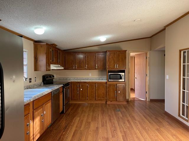 2740 Rutrough Road Southeast Roanoke, VA 24014 - Photo 3 of 27 a kitchen with stainless steel appliances a microwave a stove a sink dishwasher a refrigerator and cabinets with wooden floor