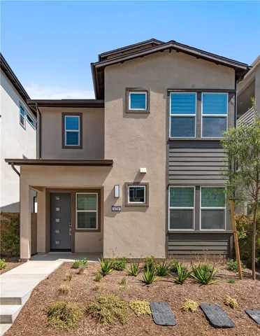 a front view of a house with yard and parking