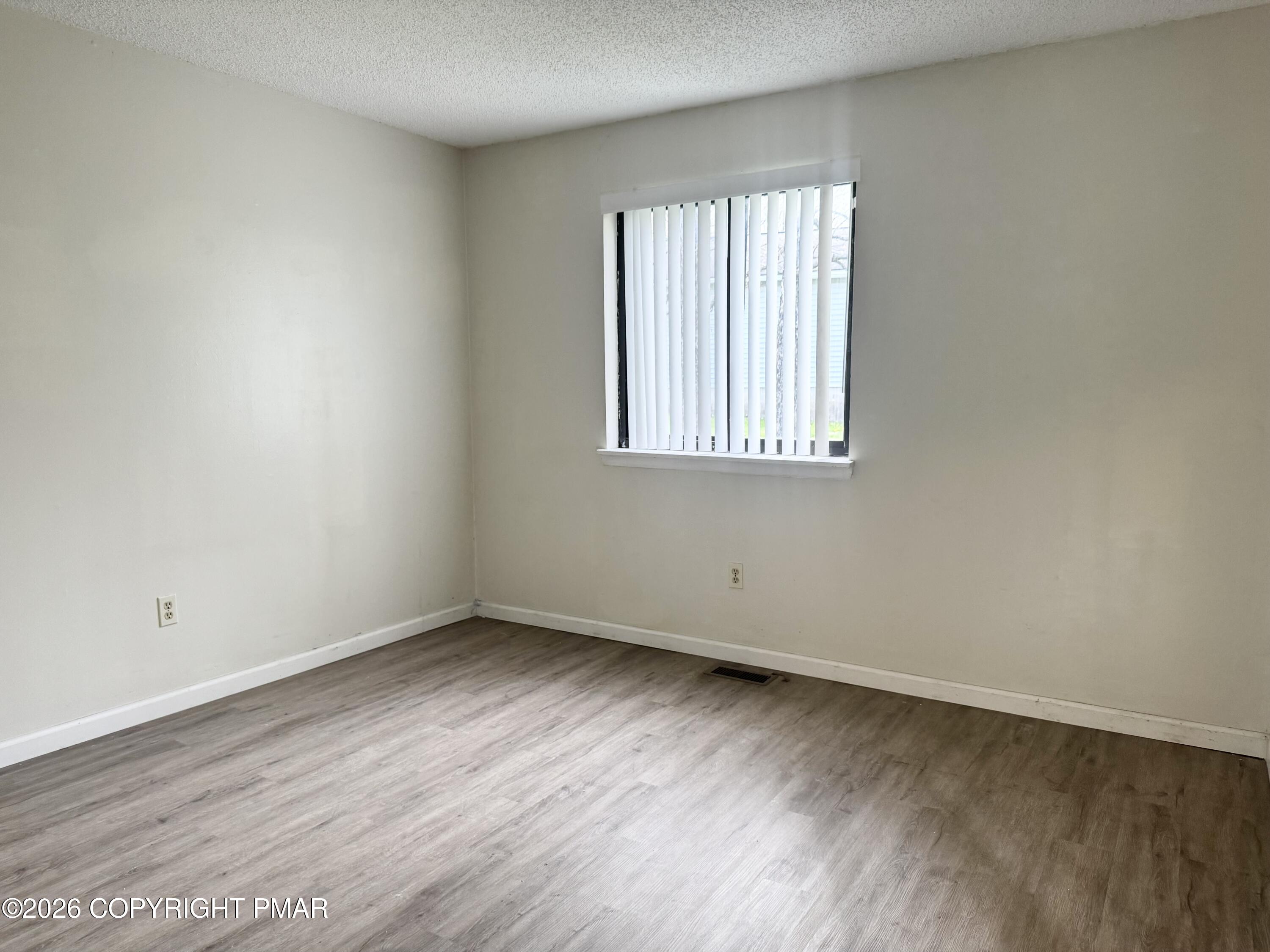 130 View Court, Unit 101 Mount Pocono, PA 18344 - Photo 13 of 17 an empty room with wooden floor and windows