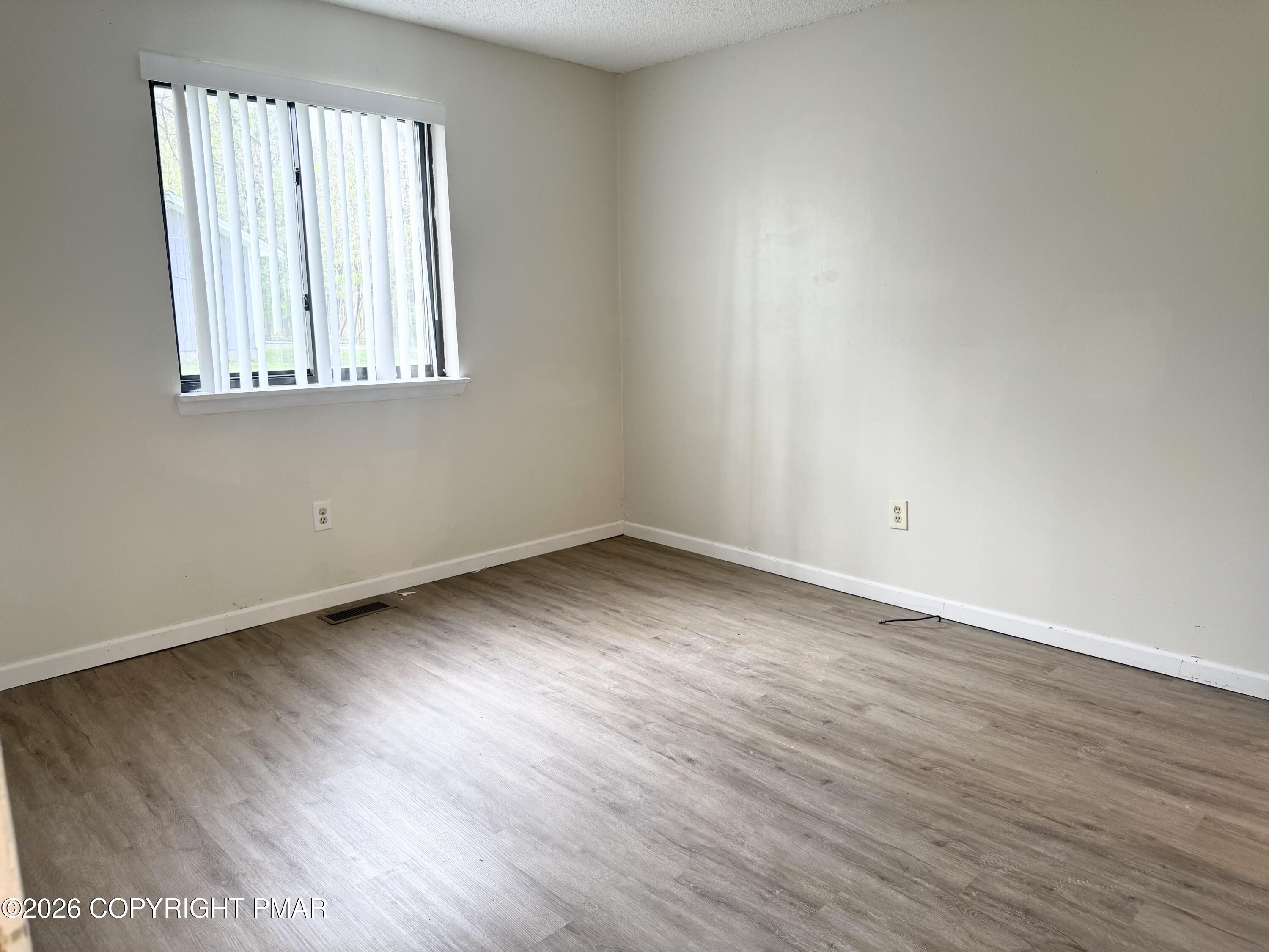 130 View Court, Unit 101 Mount Pocono, PA 18344 - Photo 15 of 17 an empty room with wooden floor and a window