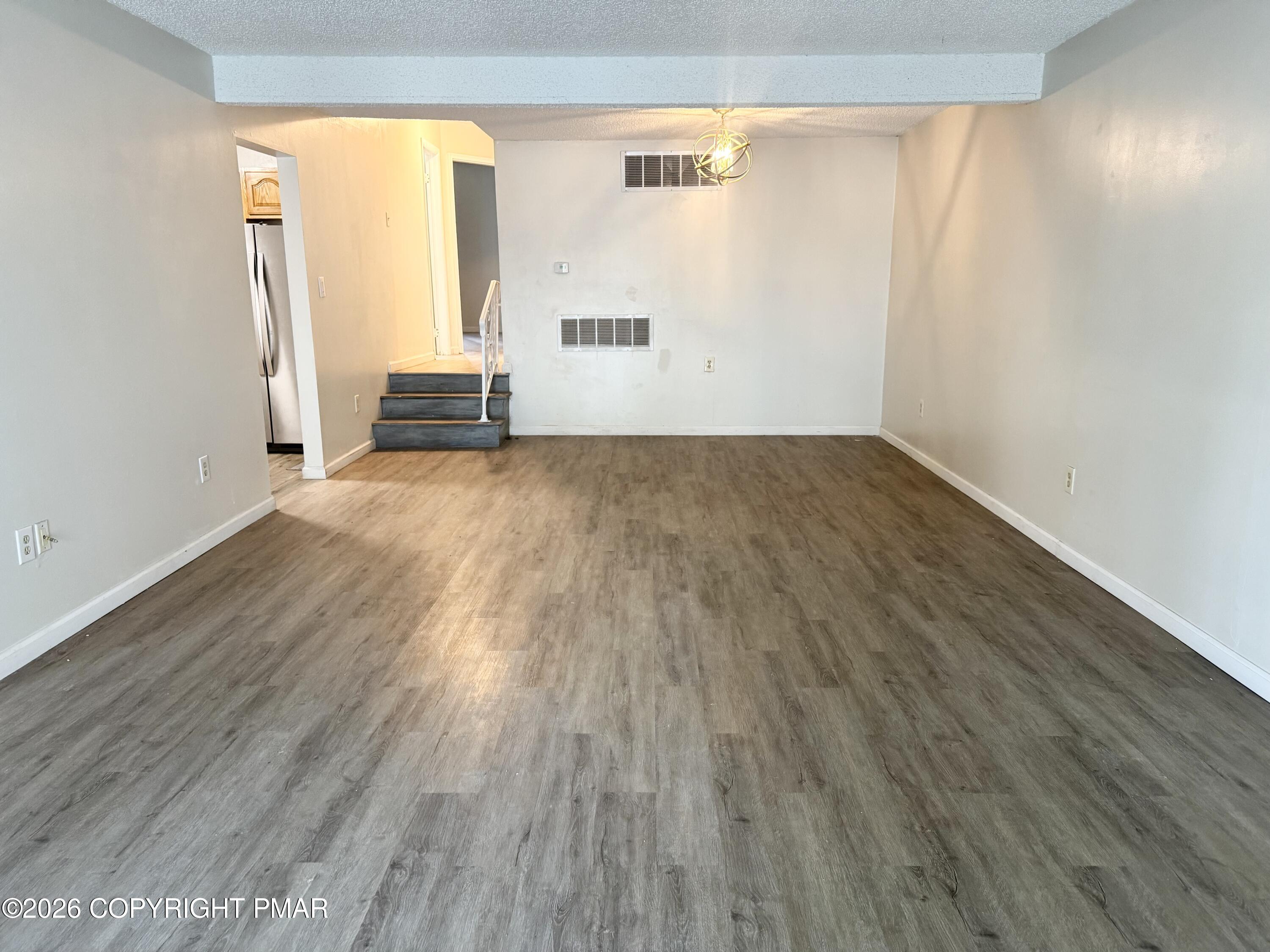 130 View Court, Unit 101 Mount Pocono, PA 18344 - Photo 4 of 17 an empty room with wooden floor and windows
