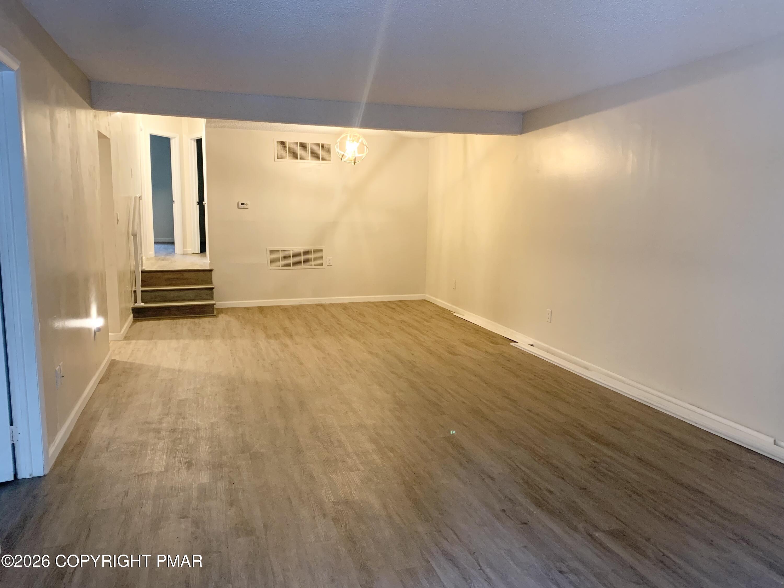 130 View Court, Unit 101 Mount Pocono, PA 18344 - Photo 5 of 8 a view of empty room with wooden floor and fan