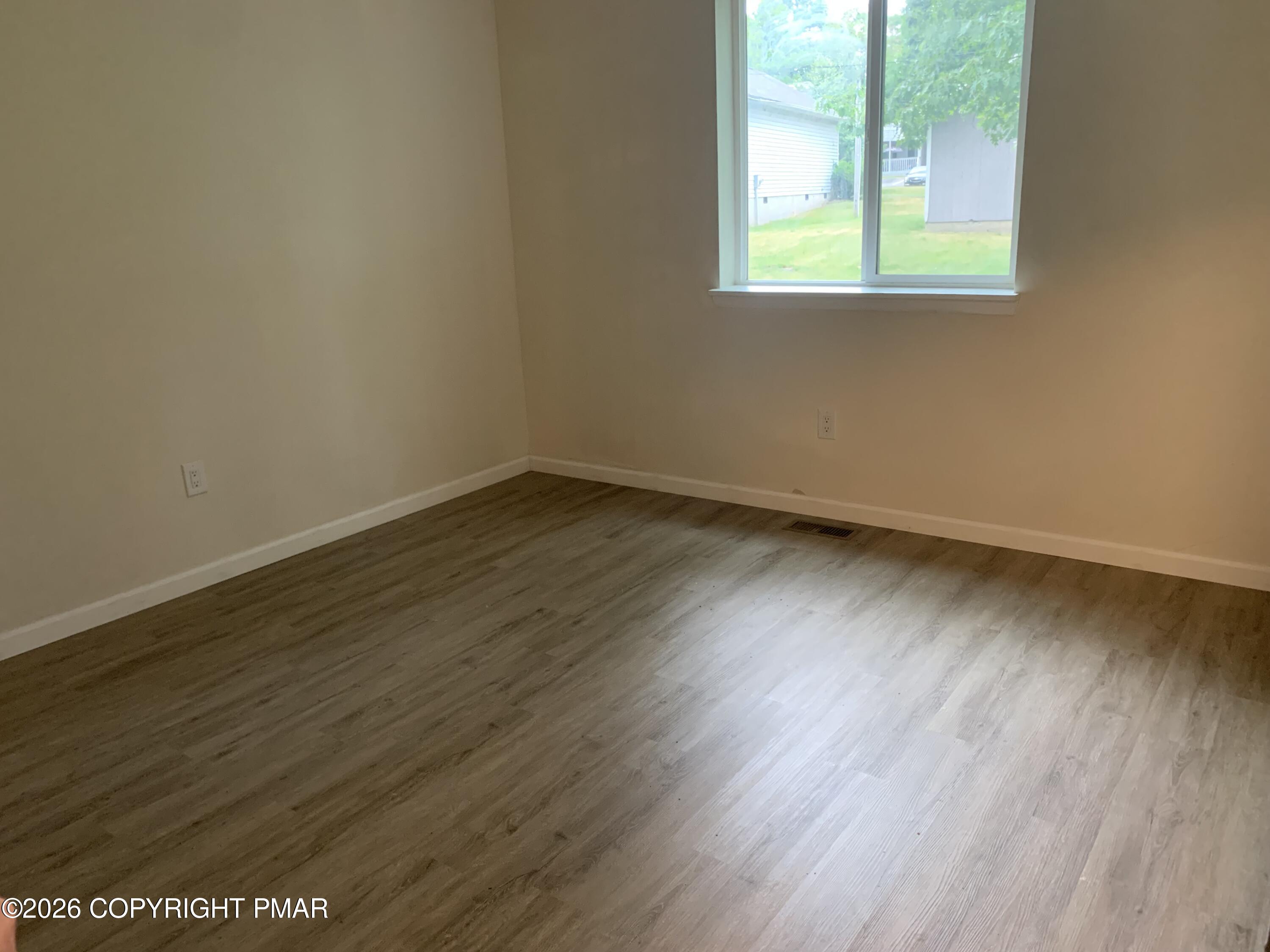 130 View Court, Unit 101 Mount Pocono, PA 18344 - Photo 6 of 8 an empty room with wooden floor and windows