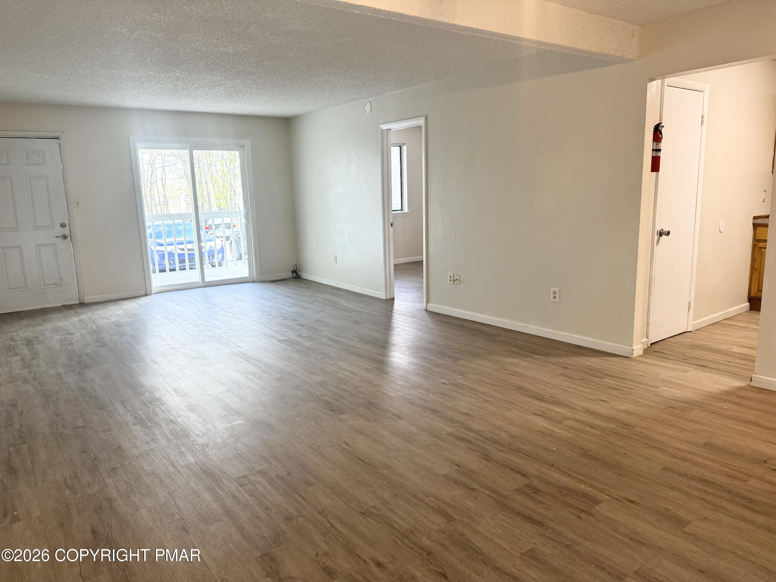 130 View Court, Unit 101 Mount Pocono, PA 18344 - Photo 6 of 17 an empty room with wooden floor and windows