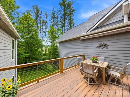 a roof deck with table and chairs and wooden floor