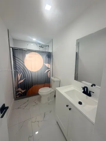 a bathroom with a sink mirror vanity and toilet