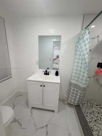 a bathroom with a sink toilet and shower