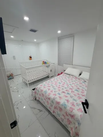 a spacious bedroom with a bed and a large mirror