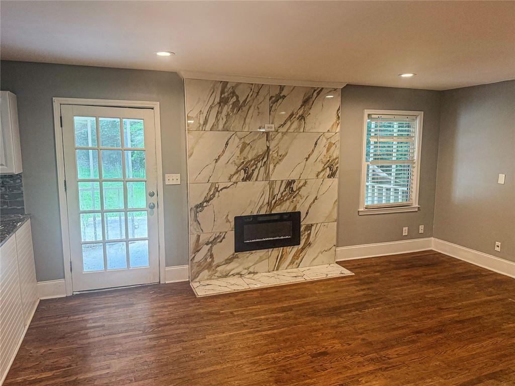 4330 Stonewall Tell Road Atlanta, GA 30349 - Photo 11 of 39 a view of wooden floor fire place and windows in a room