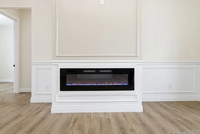 a living room with a fireplace and wooden floor