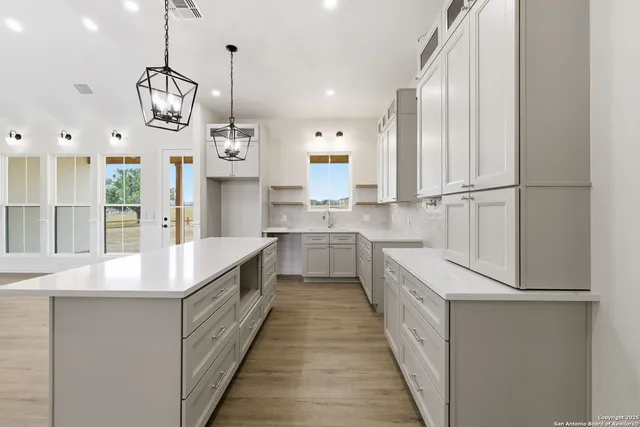 a kitchen with kitchen island granite countertop cabinets and refrigerator