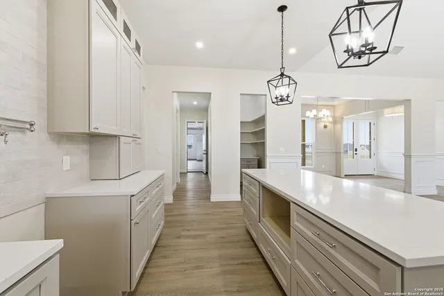 a kitchen with stainless steel appliances granite countertop a sink a counter space wooden floor and cabinets