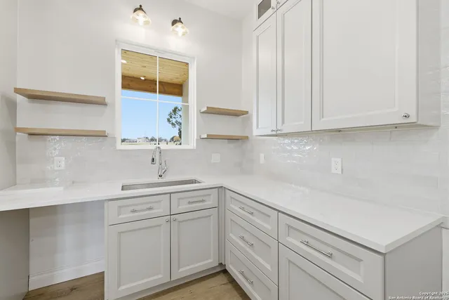 a kitchen with white cabinets and white appliances