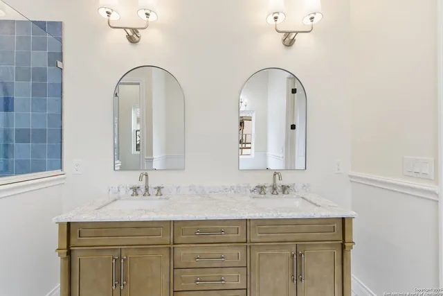 a bathroom with a double vanity sink mirror and shower