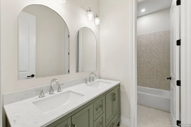 a bathroom with a double vanity sink and a mirror