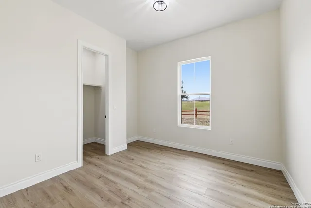 an empty room with wooden floor and window