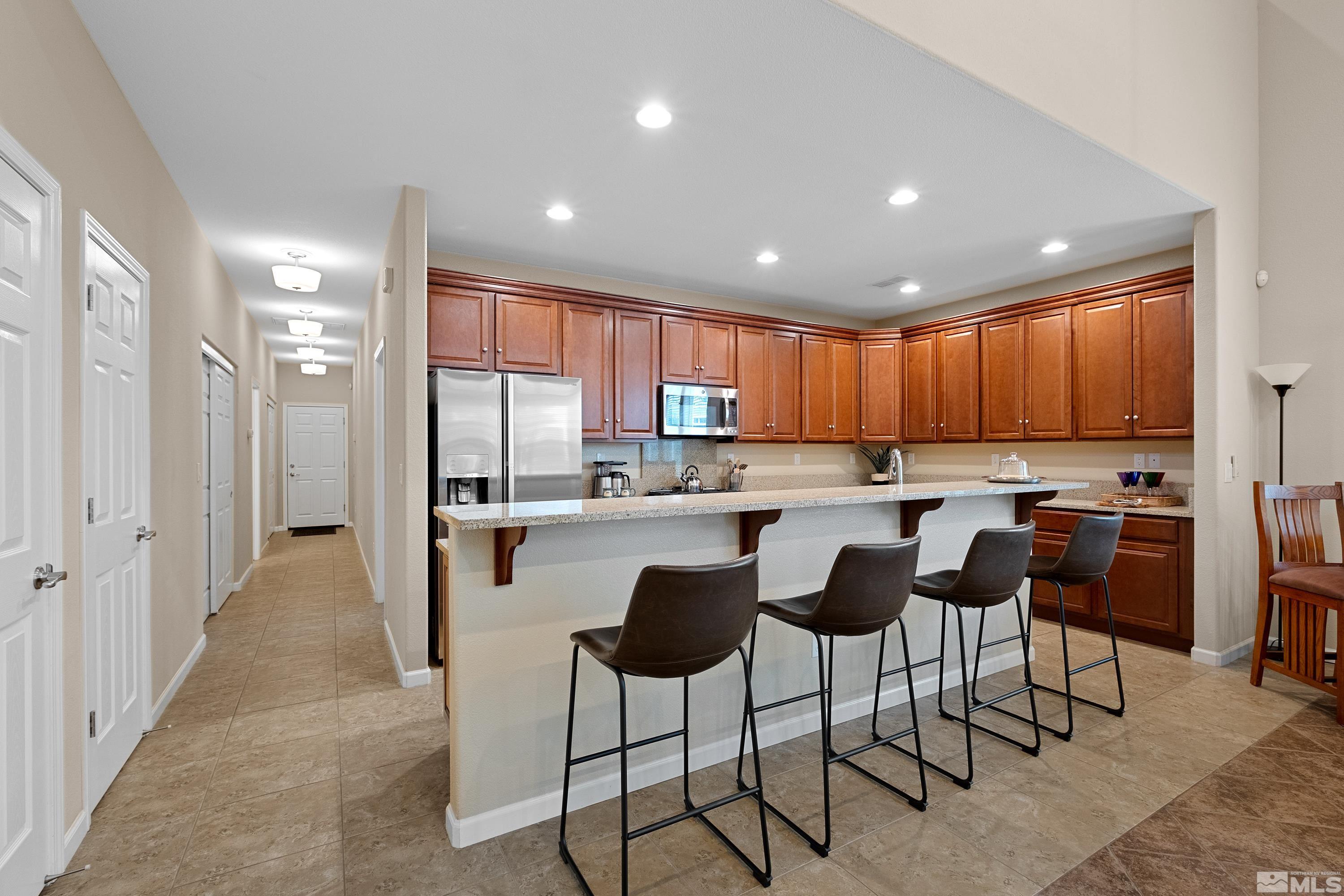 235 Brenham Avenue Reno, NV 89509 - Photo 2 of 32 a kitchen with stainless steel appliances kitchen island granite countertop a refrigerator and cabinets