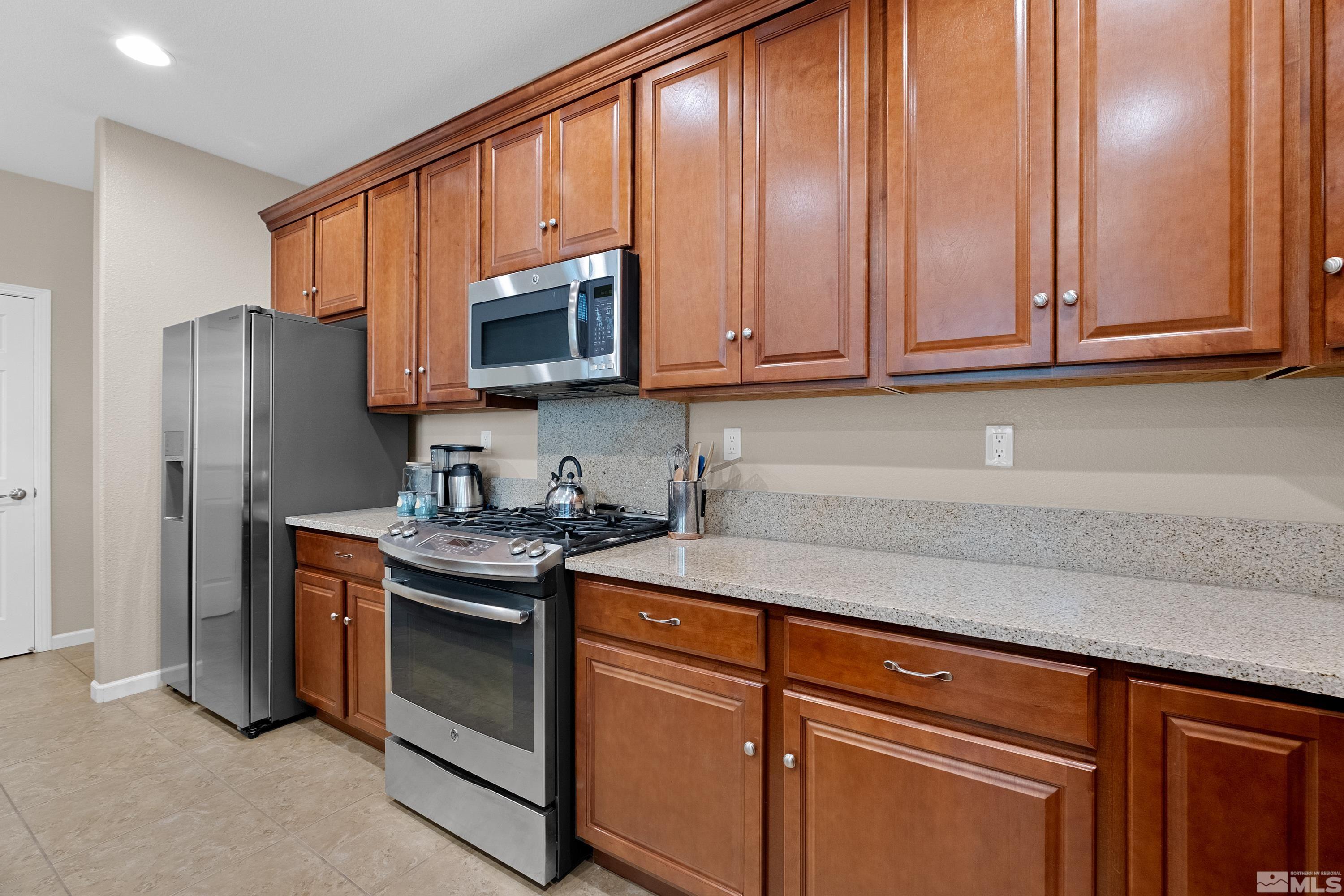 235 Brenham Avenue Reno, NV 89509 - Photo 3 of 32 a kitchen with stainless steel appliances granite countertop a sink stove and refrigerator
