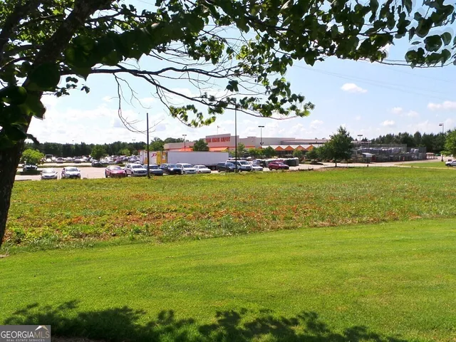 a view of an ocean with house and trees in the background