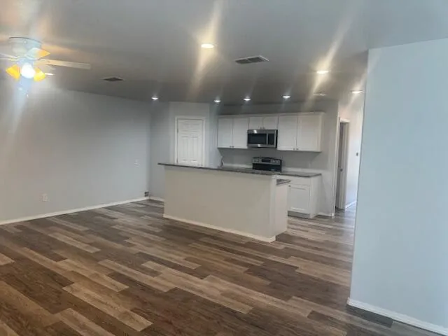 a kitchen with granite countertop a sink and a stove top oven