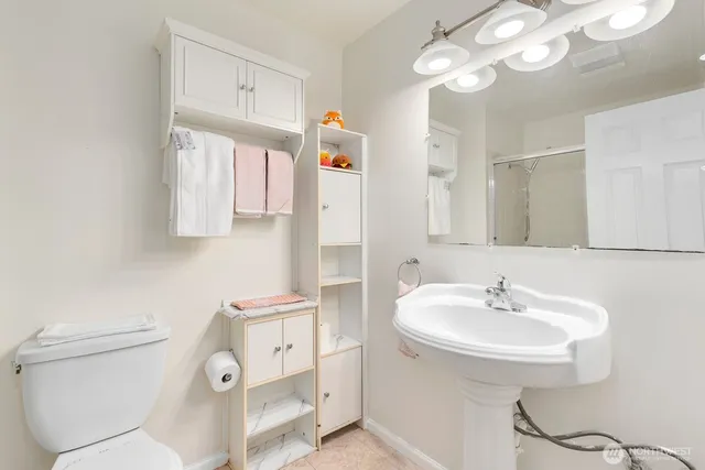 a bathroom with a sink a toilet and a mirror