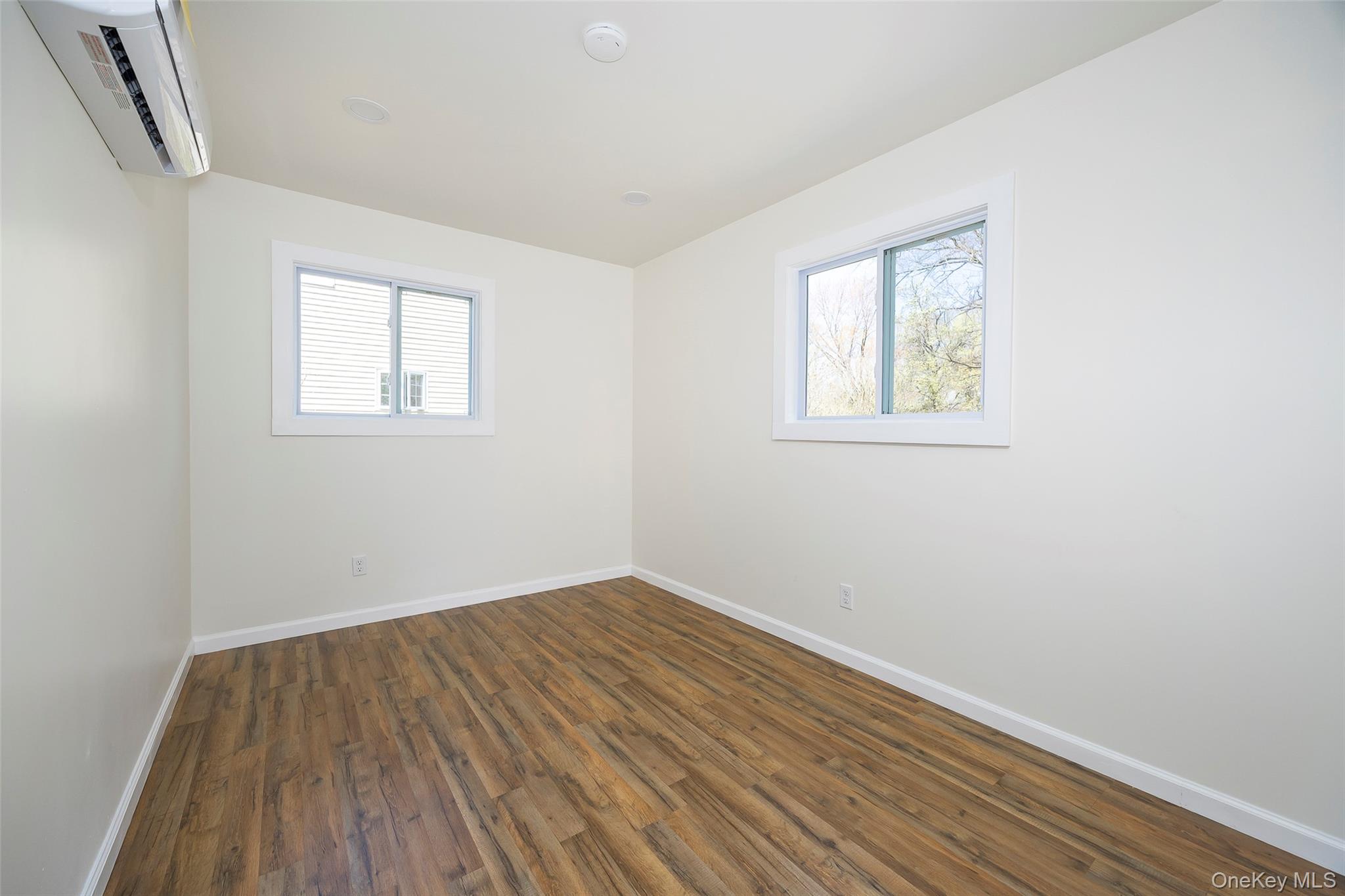 565 Old Hopewell Road Hopewell Junction, NY 12533 - Photo 11 of 23 Spare room featuring dark wood finished floors, healthy amount of natural light, and a wall mounted AC