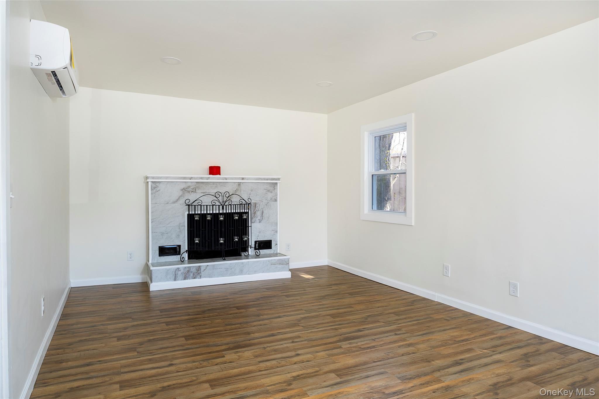 565 Old Hopewell Road Hopewell Junction, NY 12533 - Photo 5 of 23 Unfurnished living room with a premium fireplace, dark wood-style flooring, and a wall mounted AC