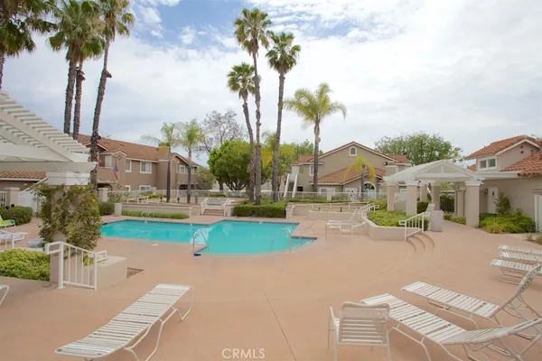 a view of a house with palm trees and a small yard
