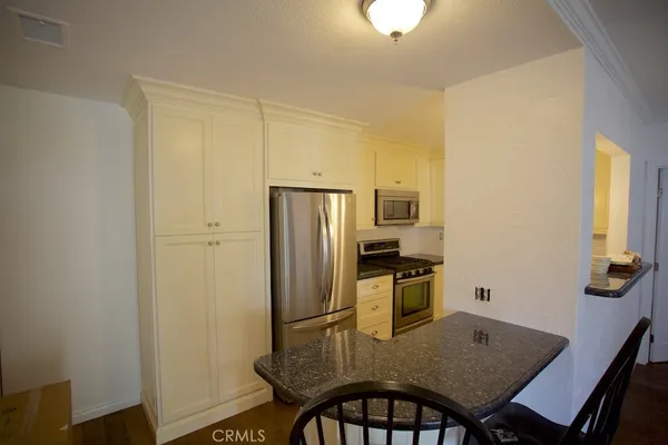 a kitchen with a table chairs refrigerator and microwave
