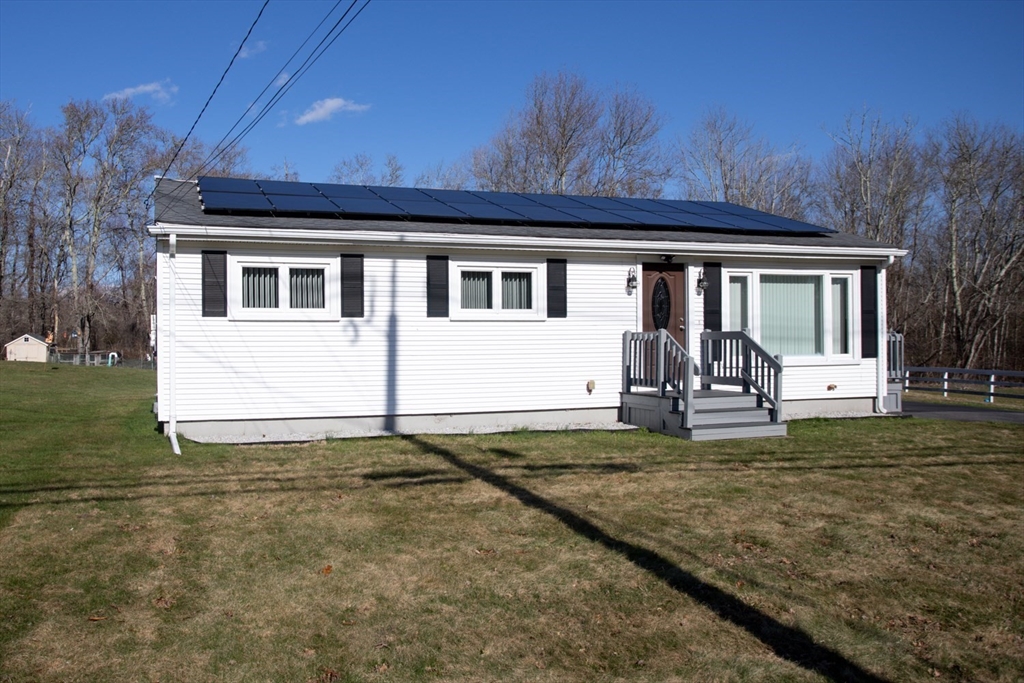a view of a house with backyard and a tree