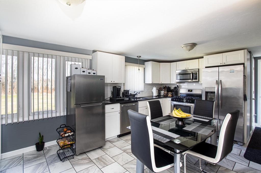 350 Gifford Road Westport, MA 02790 - Photo 14 of 39 a kitchen with a refrigerator a stove a dining table and chairs