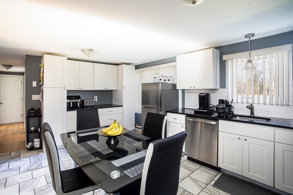 350 Gifford Road Westport, MA 02790 - Photo 16 of 39 a kitchen with stainless steel appliances a stove a sink a microwave a dining table and chairs