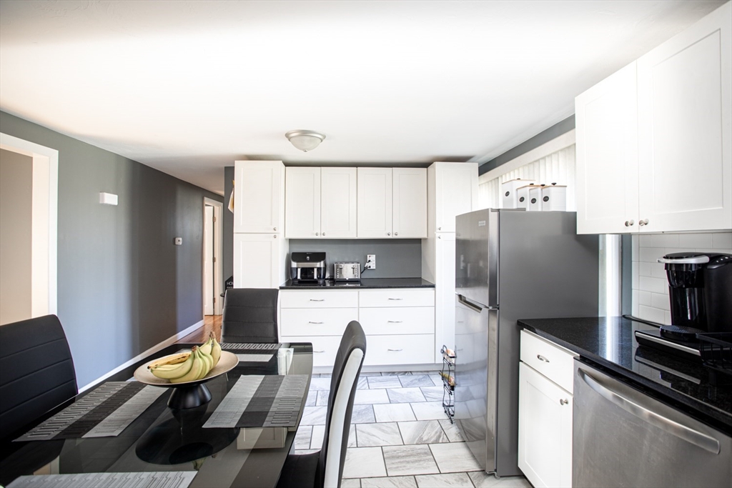 350 Gifford Road Westport, MA 02790 - Photo 17 of 39 a kitchen with refrigerator a stove a sink and a dining table with wooden floor