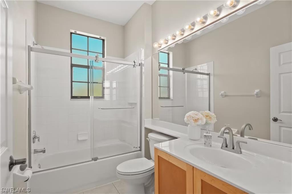 15610 Summit Pl Circle, Unit 398 Naples, FL 34119 - Photo 12 of 13 Bathroom featuring vanity, combined bath / shower with glass door, and light tile patterned flooring
