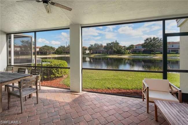 15610 Summit Pl Circle, Unit 398 Naples, FL 34119 - Photo 6 of 13 Sunroom with a water view, ceiling fan, expansive windows, outdoor dining space, and a patio