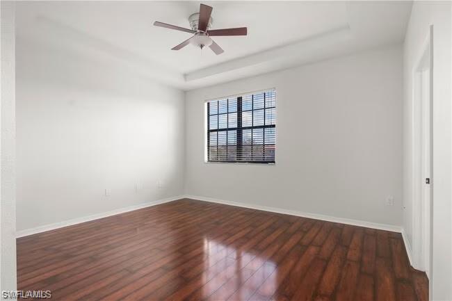 15610 Summit Pl Circle, Unit 398 Naples, FL 34119 - Photo 10 of 13 Empty room with a raised ceiling, dark wood-style floors, and ceiling fan