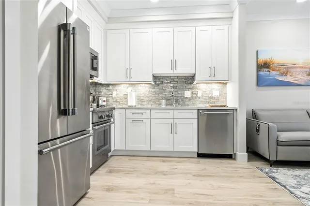 a kitchen with stainless steel appliances a refrigerator sink and cabinets