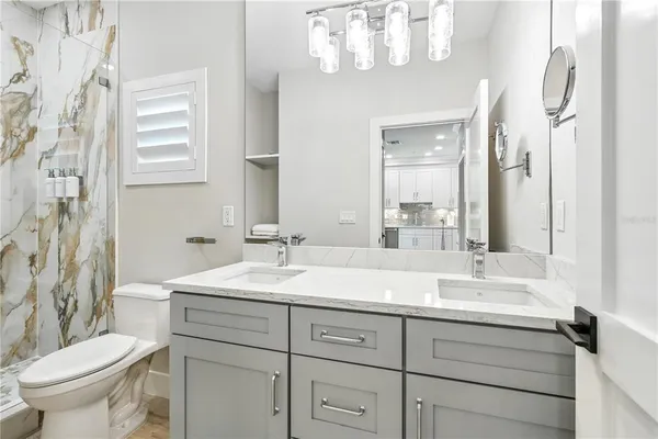 a bathroom with a double vanity sink mirror and toilet