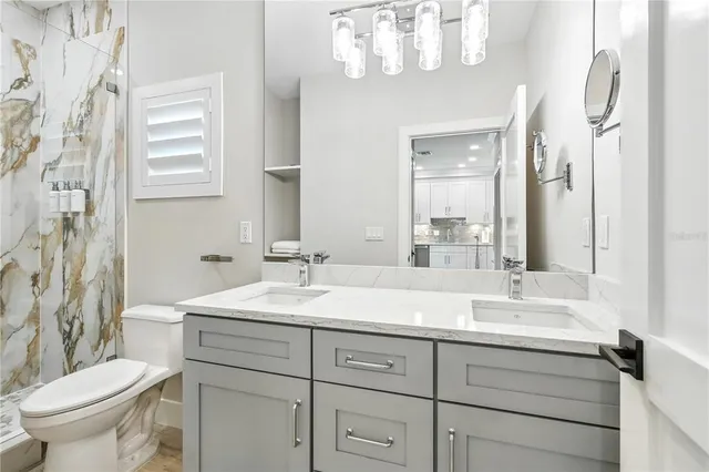 a bathroom with a double vanity sink mirror and toilet