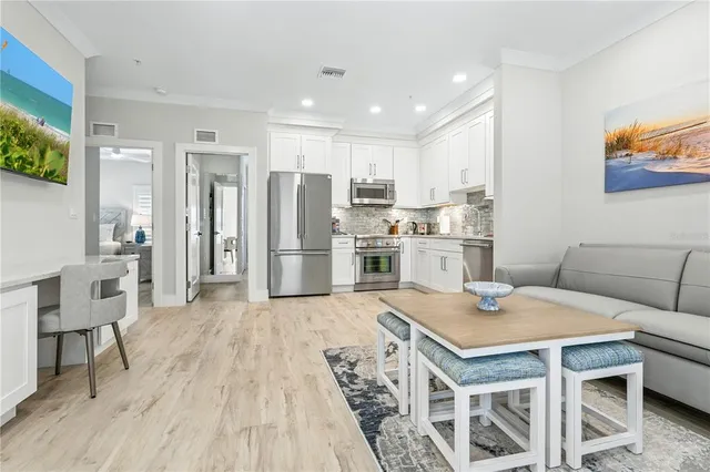 a kitchen with a table chairs refrigerator and microwave