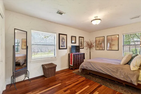 a bedroom with a bed and wooden floor