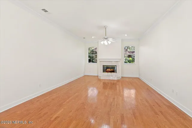 a view of empty room with wooden floor