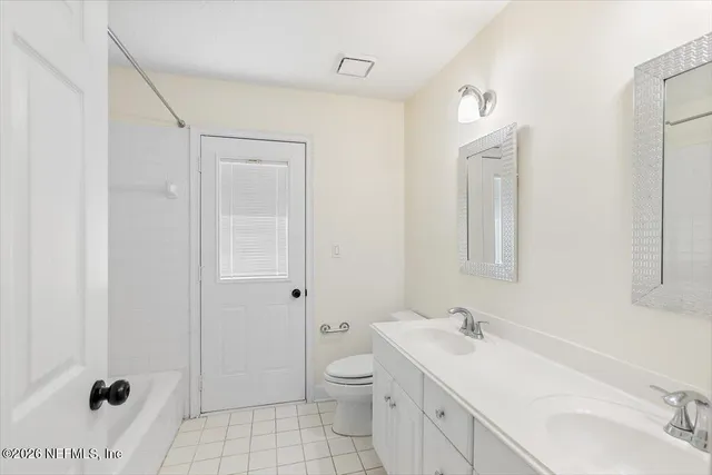 a bathroom with a toilet a sink a mirror and a shower