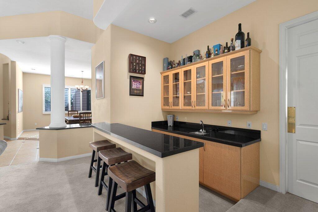 8 MacBeth Court Rancho Mirage, CA 92270 - Photo 8 of 46 a kitchen island with granite countertop a sink and cabinets