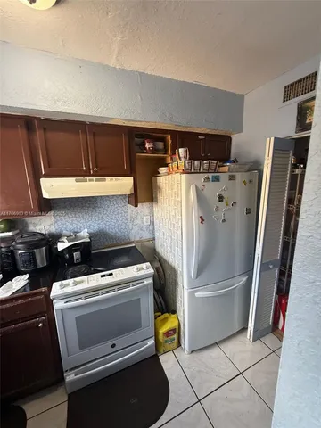 a kitchen with refrigerator and cabinets