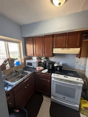 a kitchen with a sink stove and cabinets