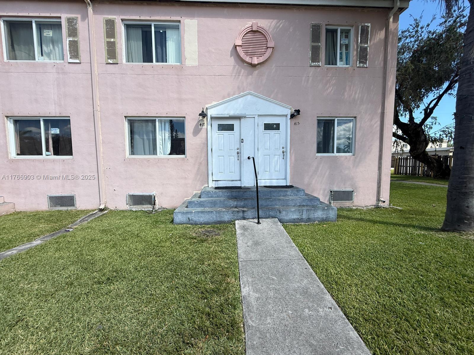 417 Northwest 84th Street, Unit 417 Miami, FL 33150 - Photo 3 of 26 a front view of a house with garden
