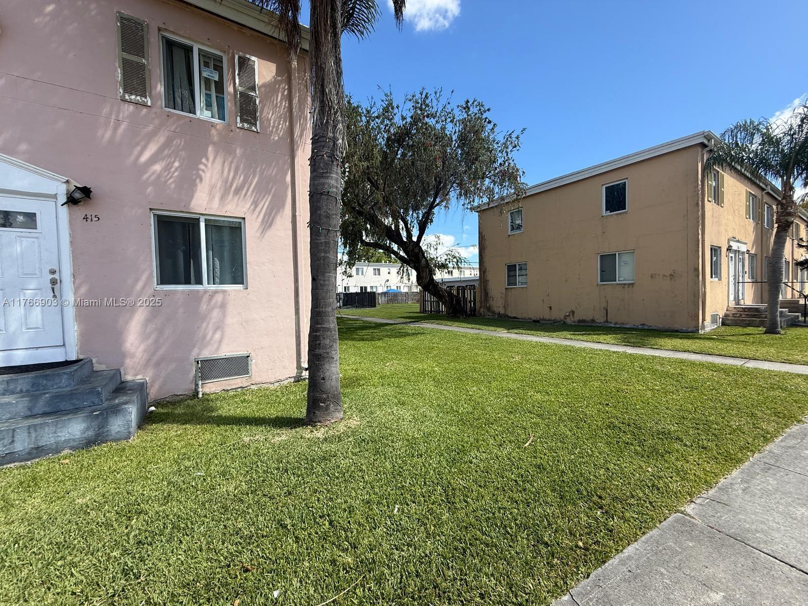 417 Northwest 84th Street, Unit 417 Miami, FL 33150 - Photo 5 of 26 a view of backyard with potted plants and large tree